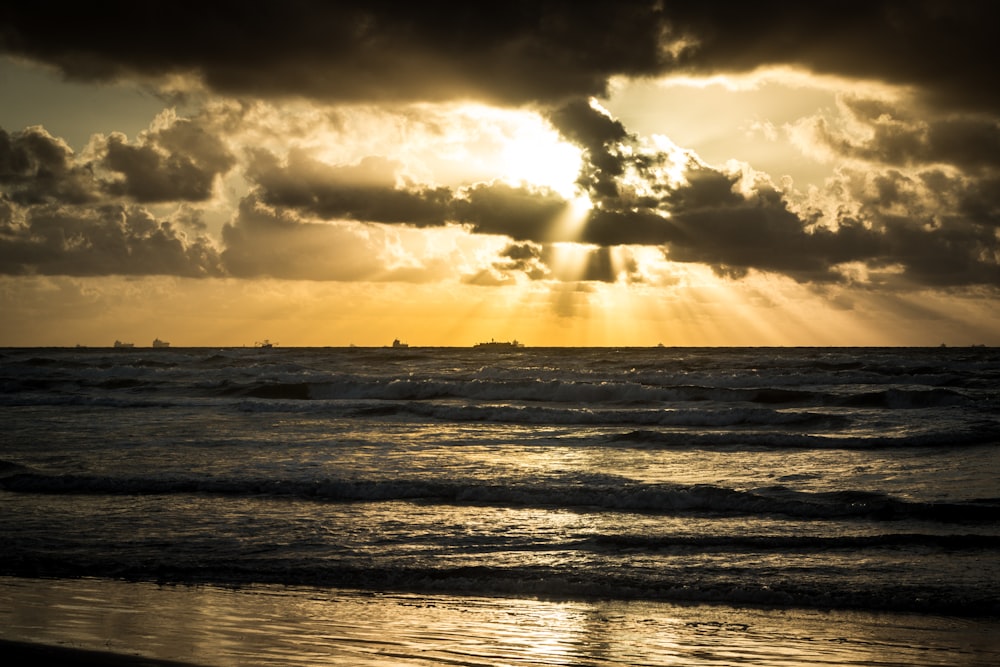 sea waves crashing on shore during sunset