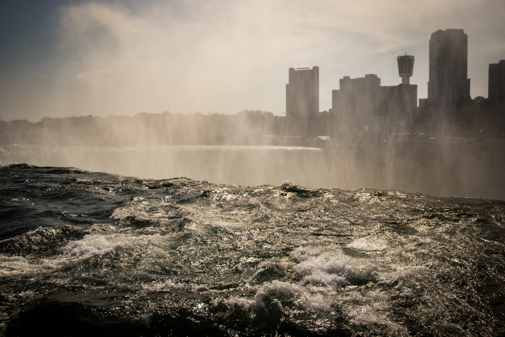 water falls on rocky shore during daytime