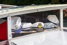 A close-up of Miami Yacht Life branded hats and shirts displayed on a wooden table.