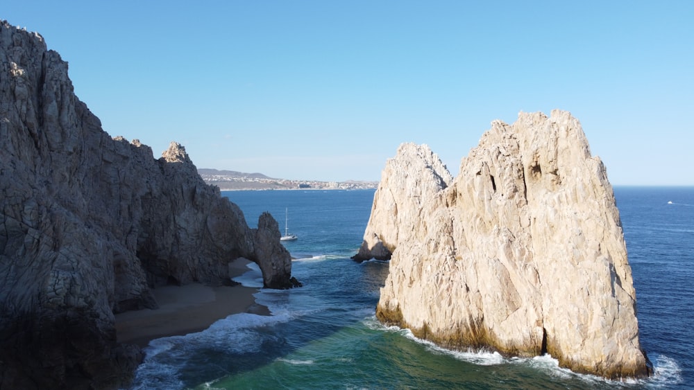 brown rock formation on sea under blue sky during daytime