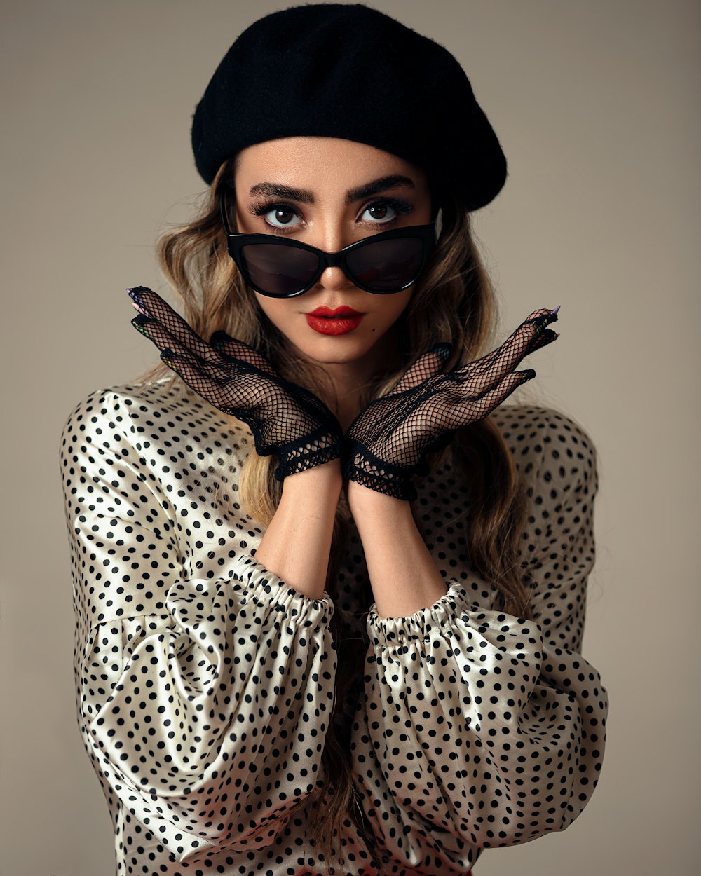 Frau in schwarz-weißem Polka-Dot-Shirt mit schwarzer Sonnenbrille