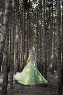 A model wearing a flowing midi dress in a forest setting.