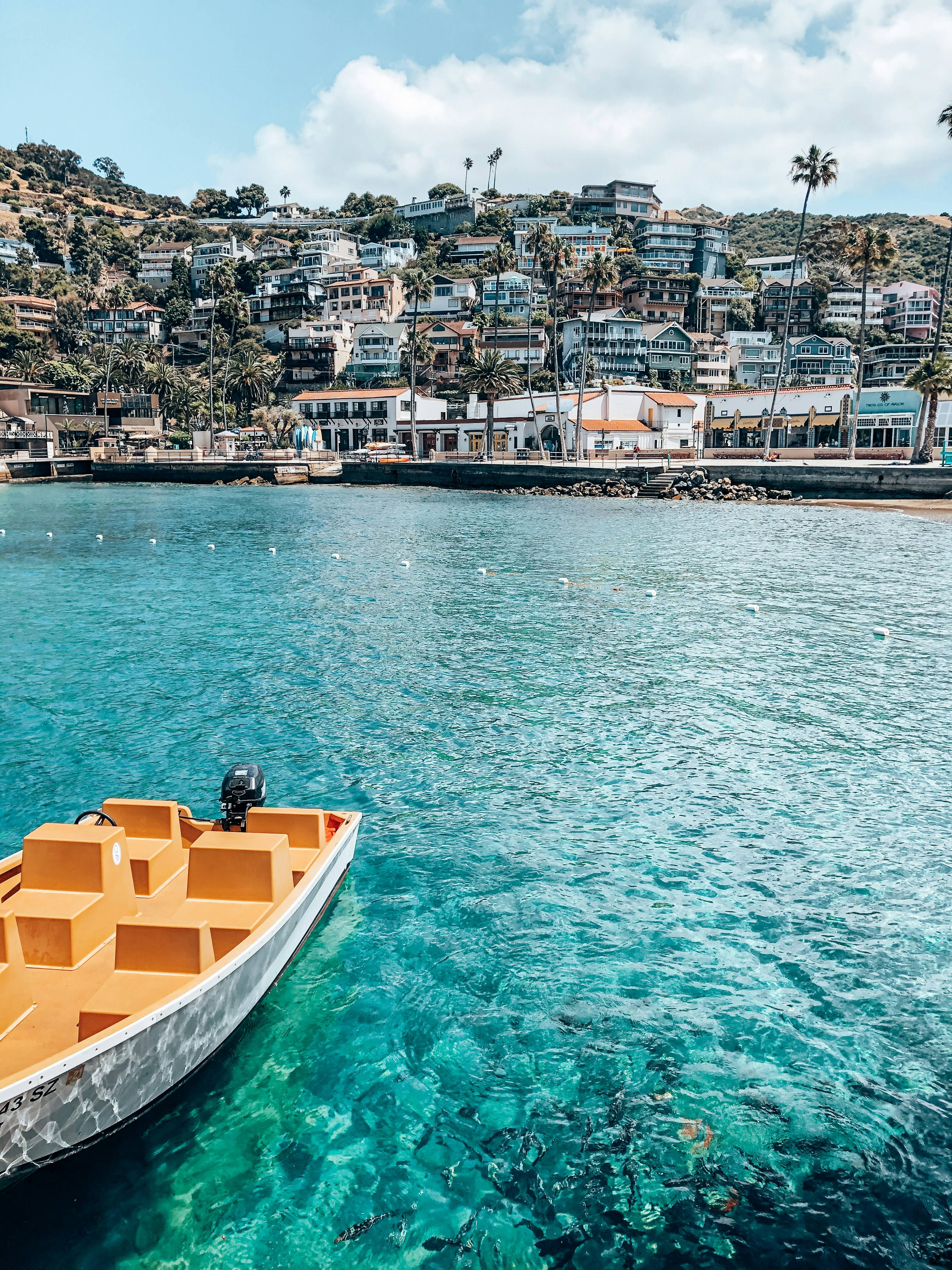 yellow and white boat on water near city buildings during daytime