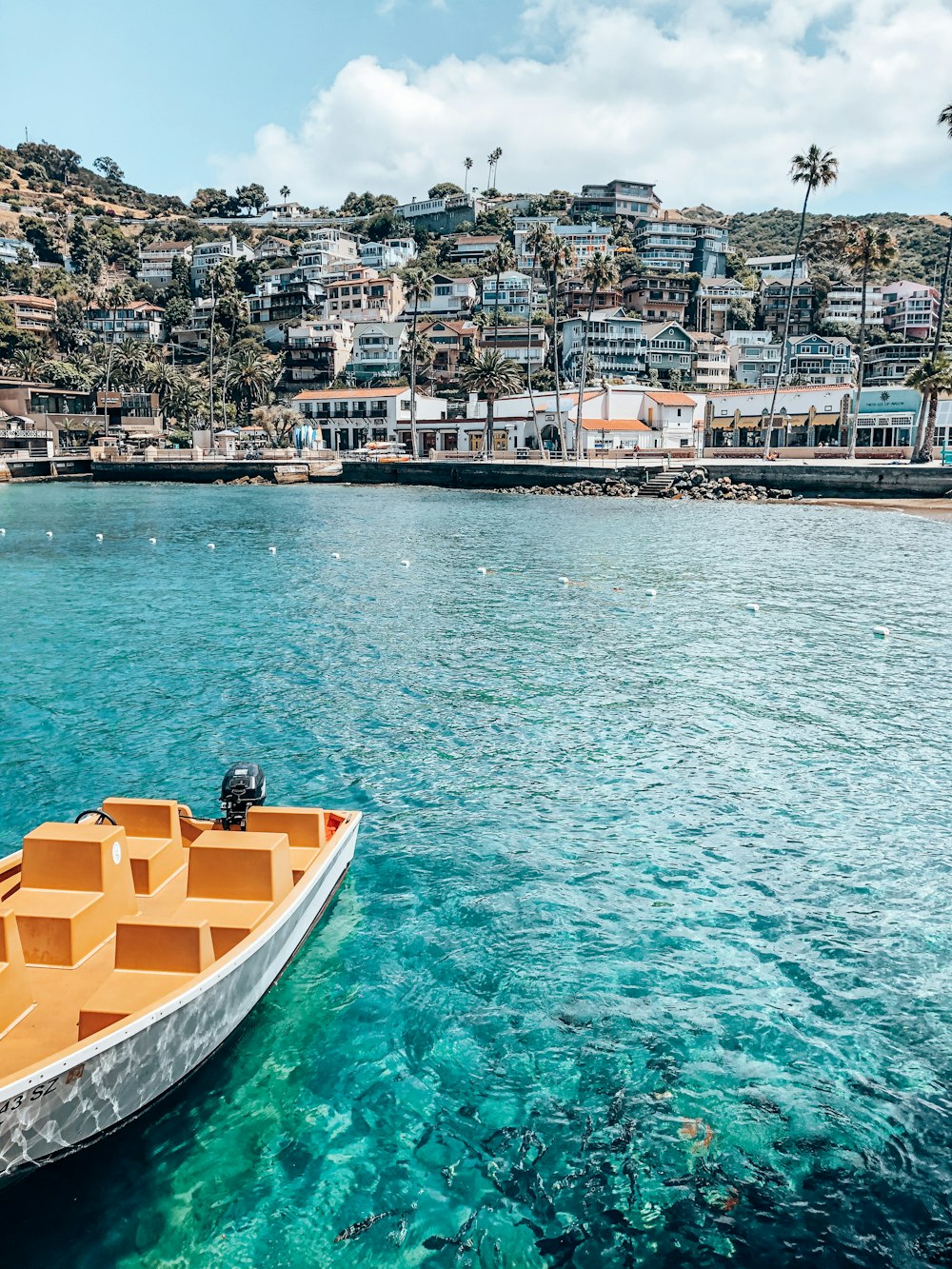 Barco amarillo y blanco en el agua cerca de los edificios de la ciudad durante el día