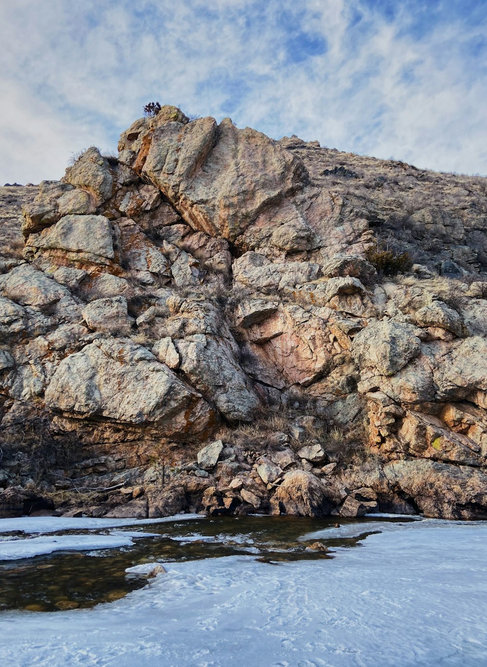 brown rock formation on body of water during daytime