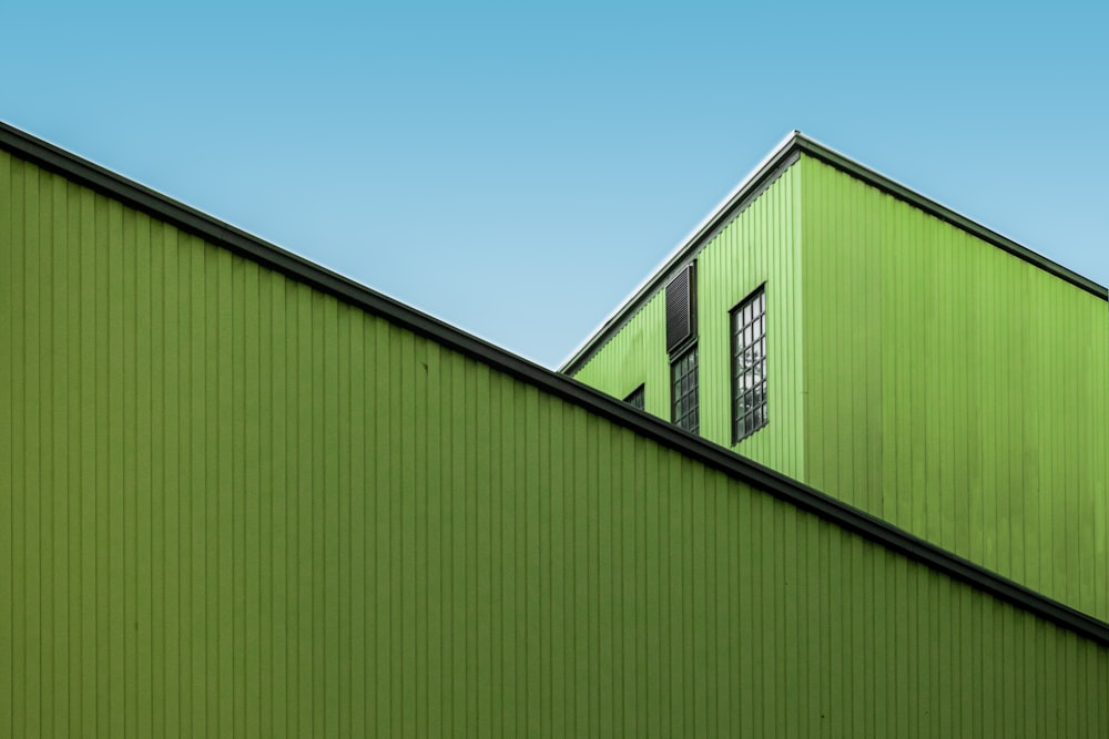 grün-weißes Holzhaus unter blauem Himmel tagsüber