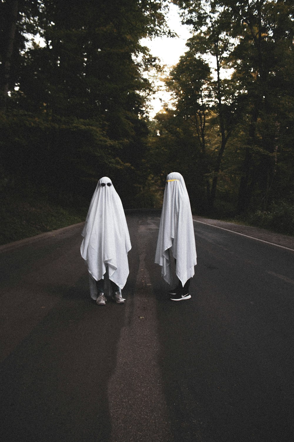 person in white robe walking on road during daytime