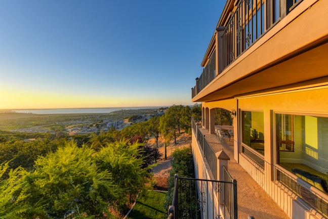Guests enjoying a scenic view from a hotel balcony at sunset.
