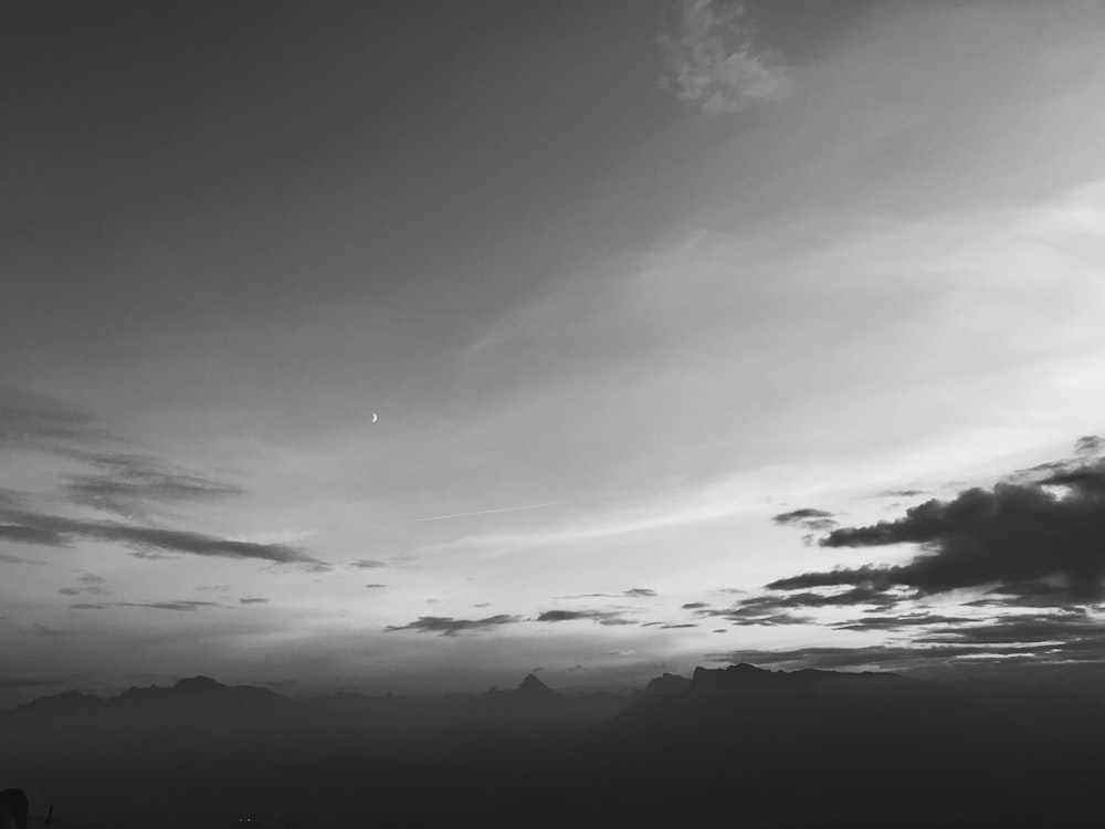 grayscale photo of clouds and mountains