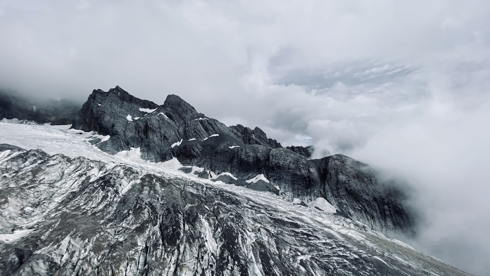 snow covered mountain under cloudy sky during daytime