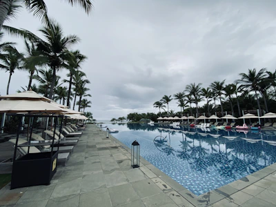 A family enjoying the poolside with colorful umbrellas and bright lounge chairs.