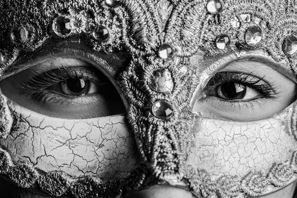 grayscale photo of person with silver glitter face mask