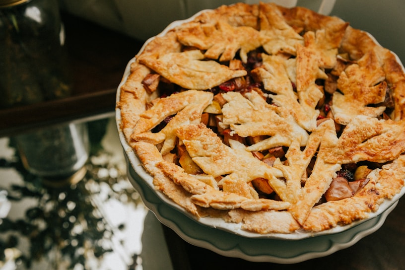 Close-up of a golden-brown apple pie fresh out of the oven with steam rising.