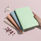 person holding green covered book