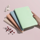 person holding green covered book