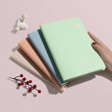 person holding green covered book