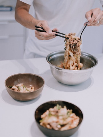 person holding stainless steel spoon and fork