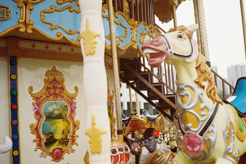 white and yellow carousel with lights turned on during daytime