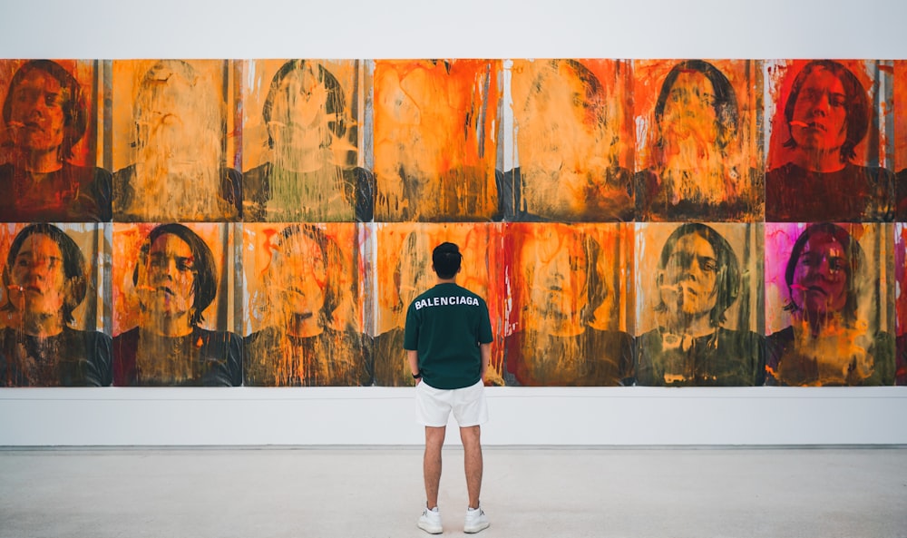 man in black long sleeve shirt and white shorts standing in front of brown and black