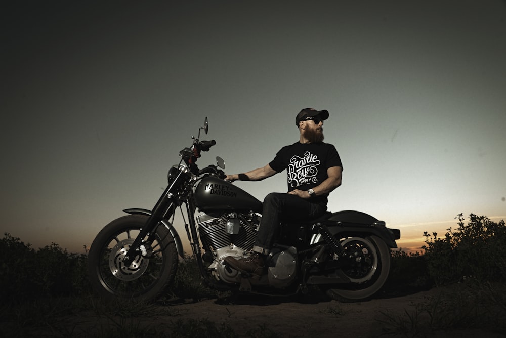 uomo in t-shirt nera in sella a moto