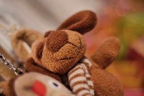 A close-up of a soft, smiling plush bear with stitched details.