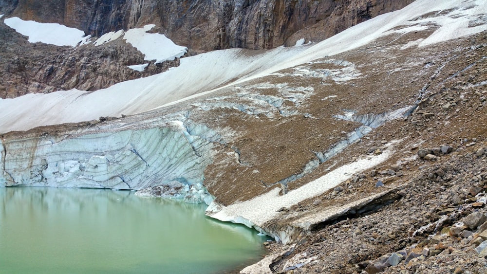 lake in the middle of snow covered mountains