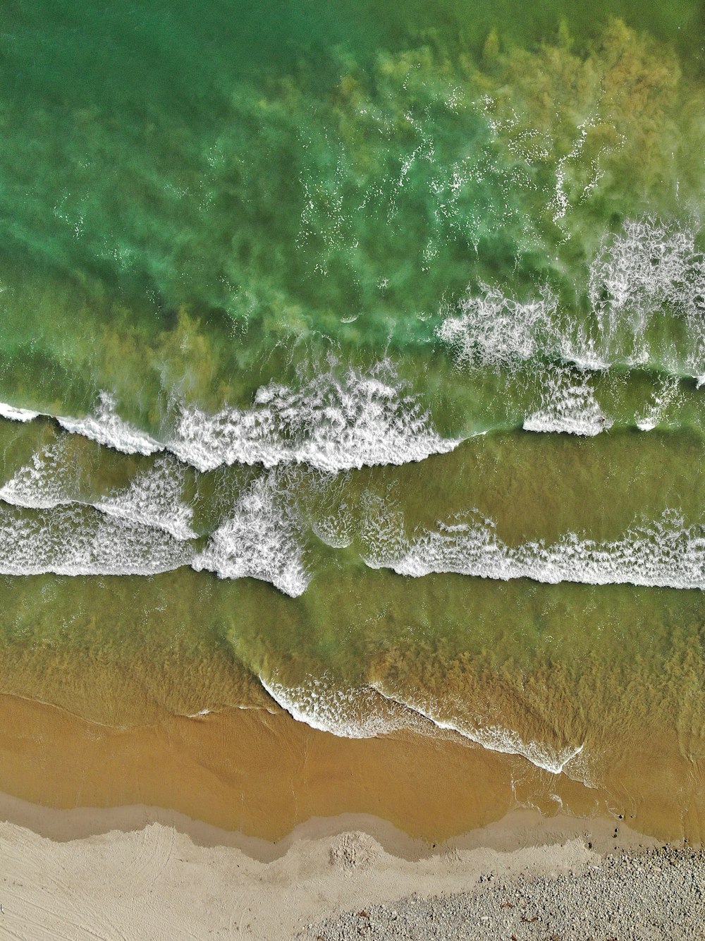 aerial view of ocean waves on shore during daytime