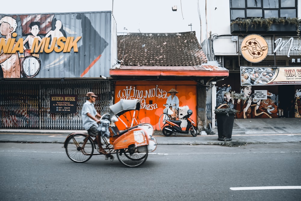 man in white shirt riding on orange motorcycle during daytime