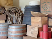 Stacks of aged wooden crates and metal buckets in the shop corner.