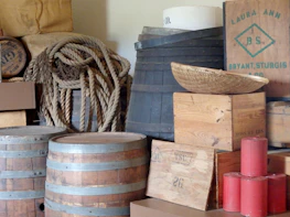 Stacks of aged wooden crates and metal buckets in the shop corner.