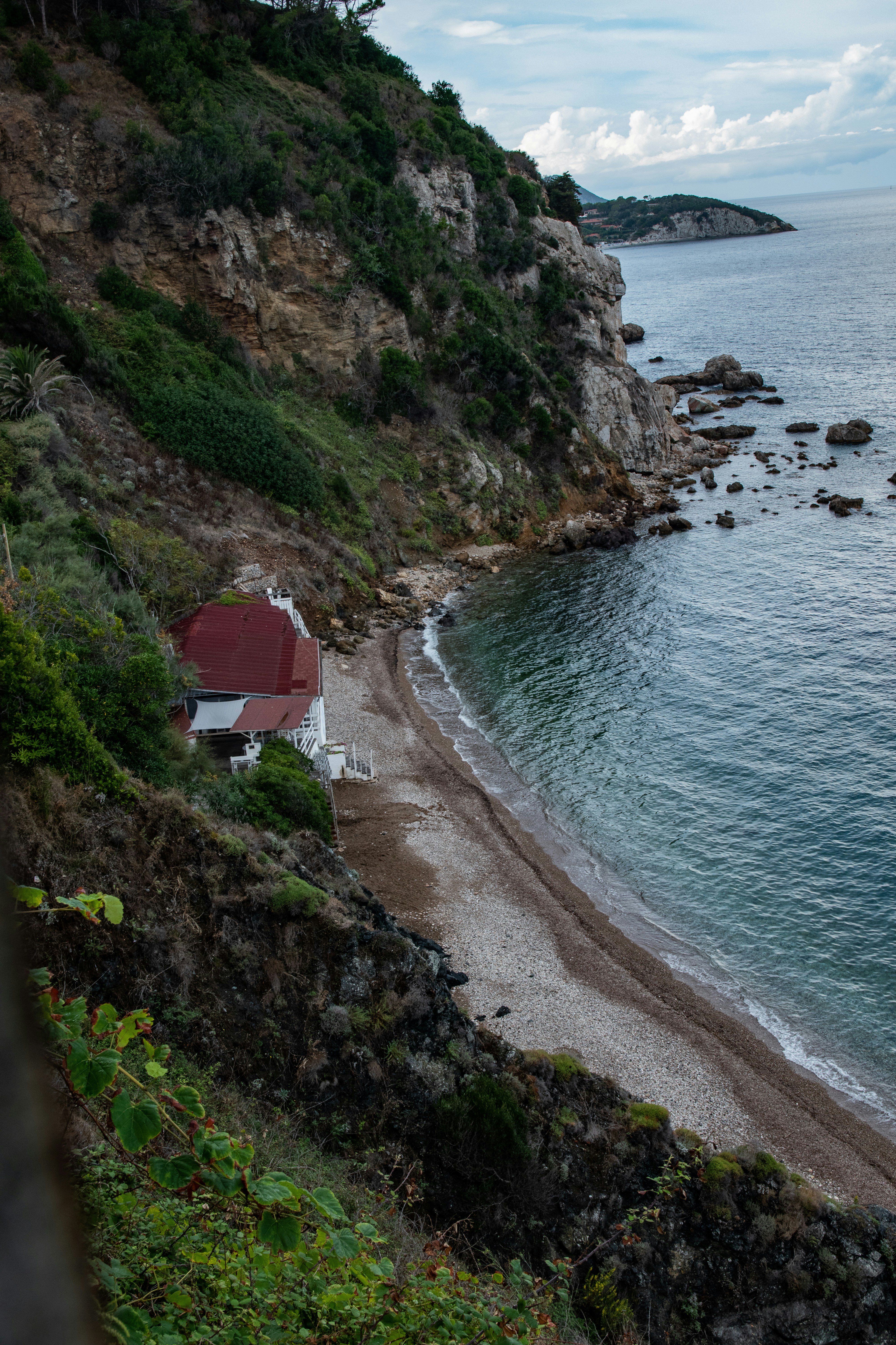 red and white house on cliff by the sea