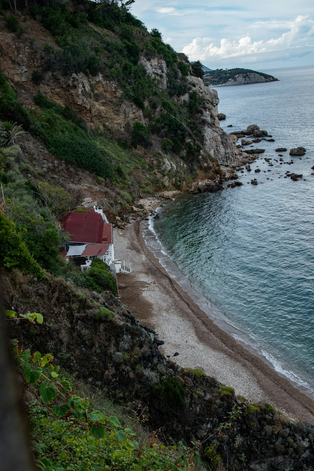 red and white house on cliff by the sea