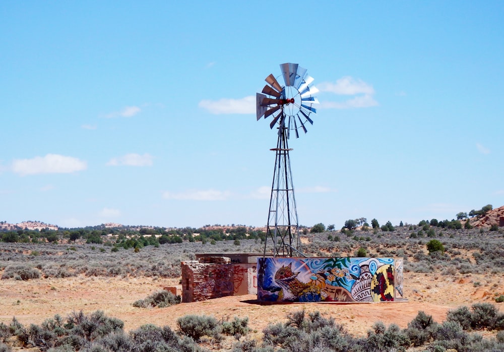 windmill on brown field under blue sky during daytime