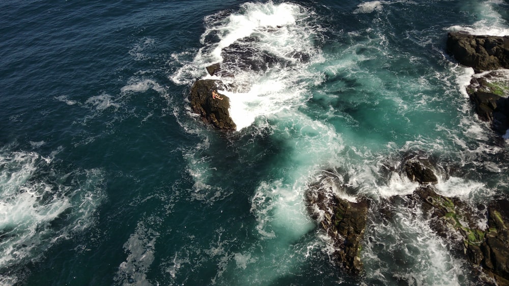 brown rock formation beside body of water during daytime