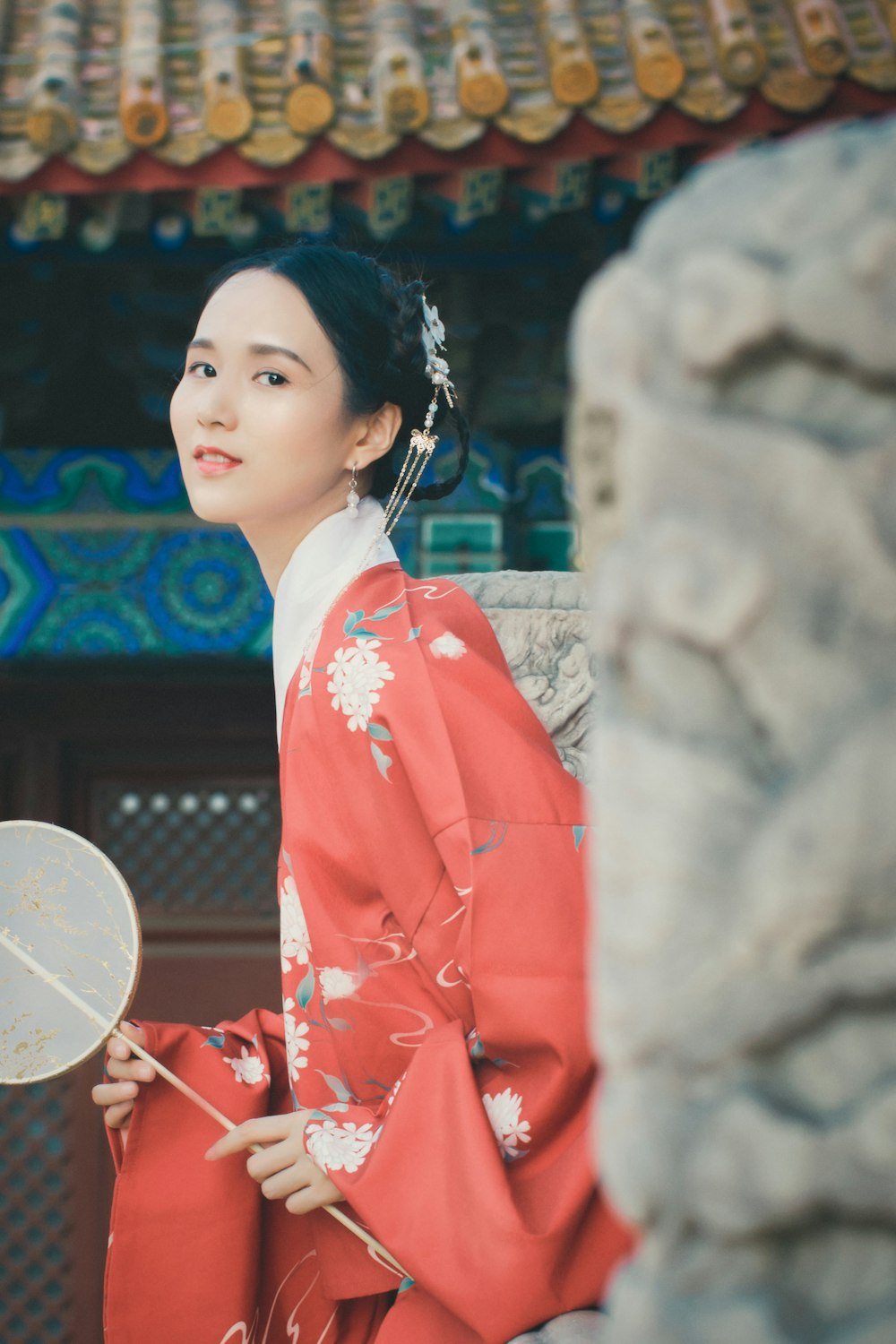 girl in red and white floral robe holding white hand fan