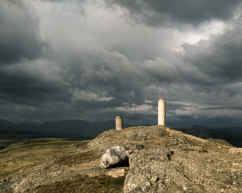 white concrete tower on green grass field under gray clouds