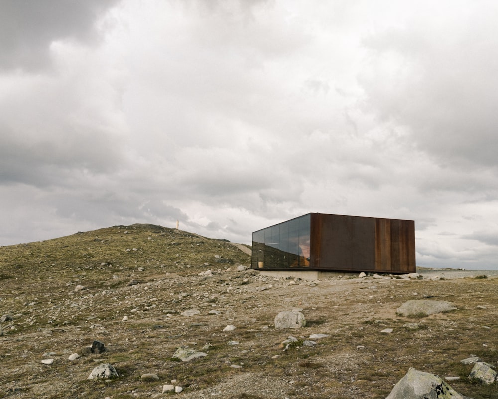 brown wooden shed on green grass field under white cloudy sky during daytime