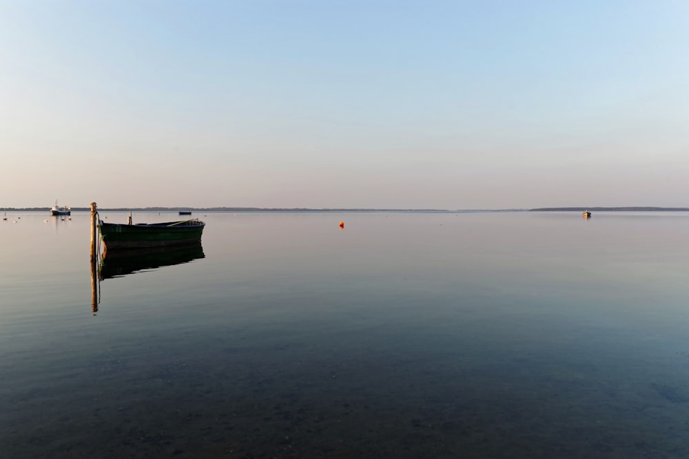 boat on calm sea under gray sky