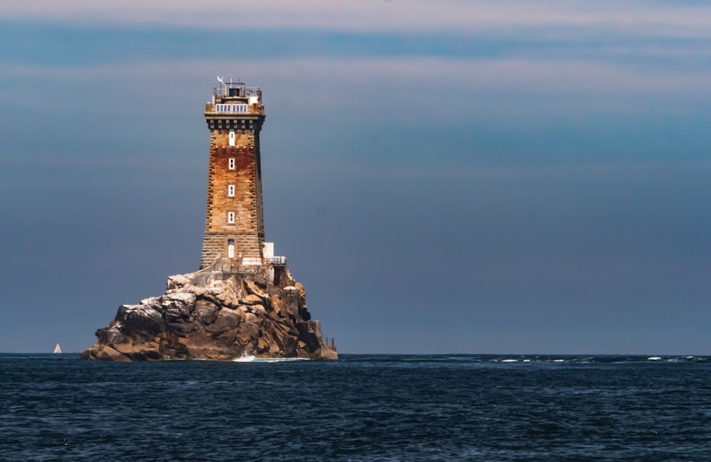 brown and white lighthouse on the sea during daytime