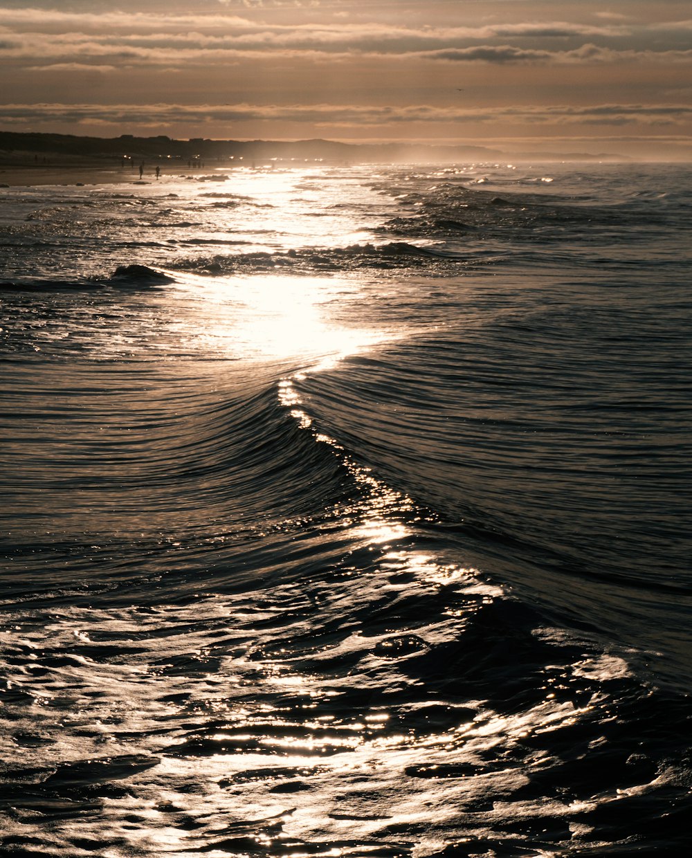 ocean waves crashing on shore during sunset