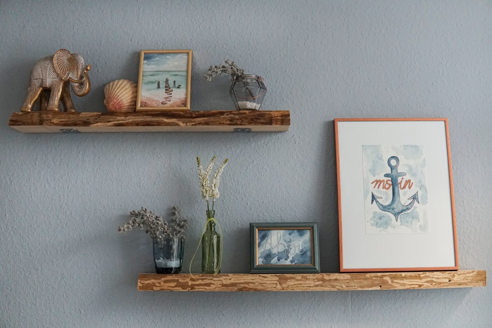 white flowers in clear glass vase on brown wooden wall shelf