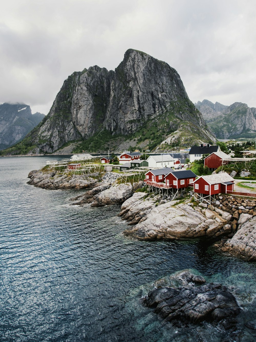 houses near body of water and mountain during daytime