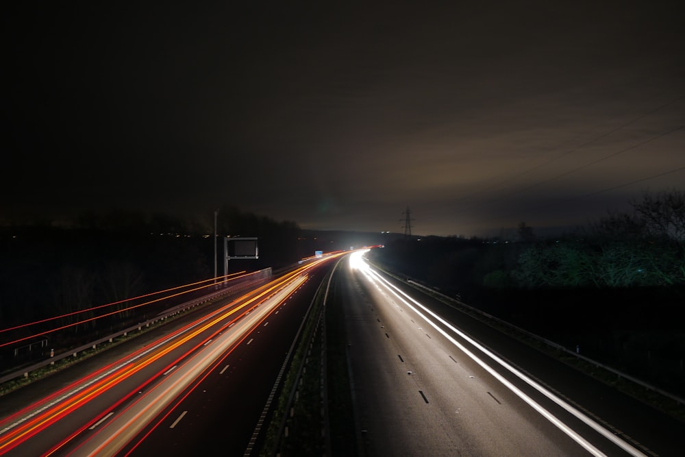 a long exposure photo of a highway at night