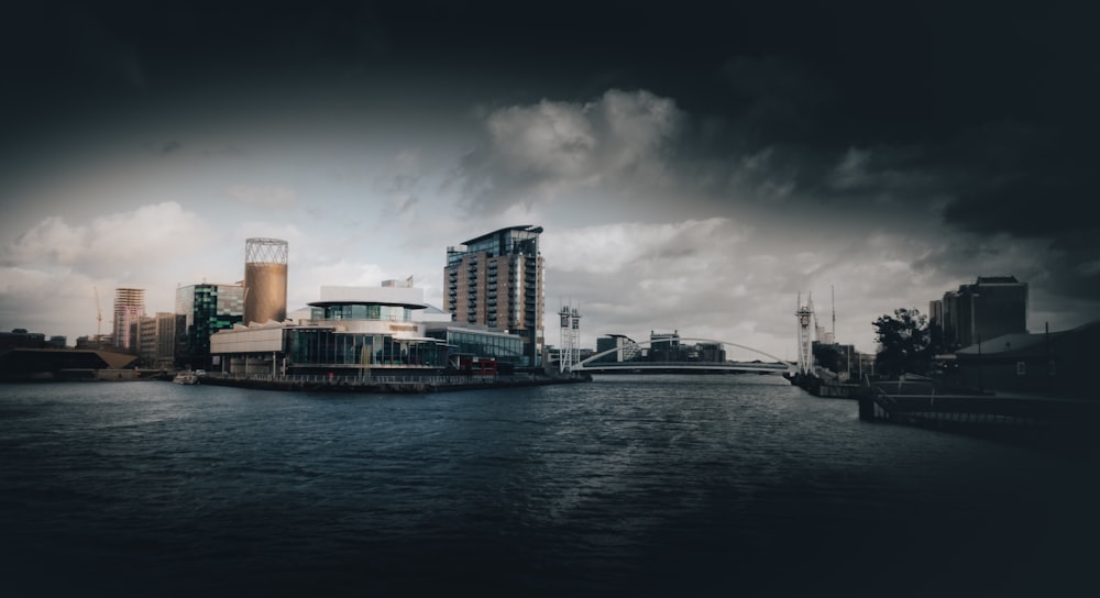 Bote blanco y negro en el cuerpo de agua cerca de los edificios de la ciudad durante el día