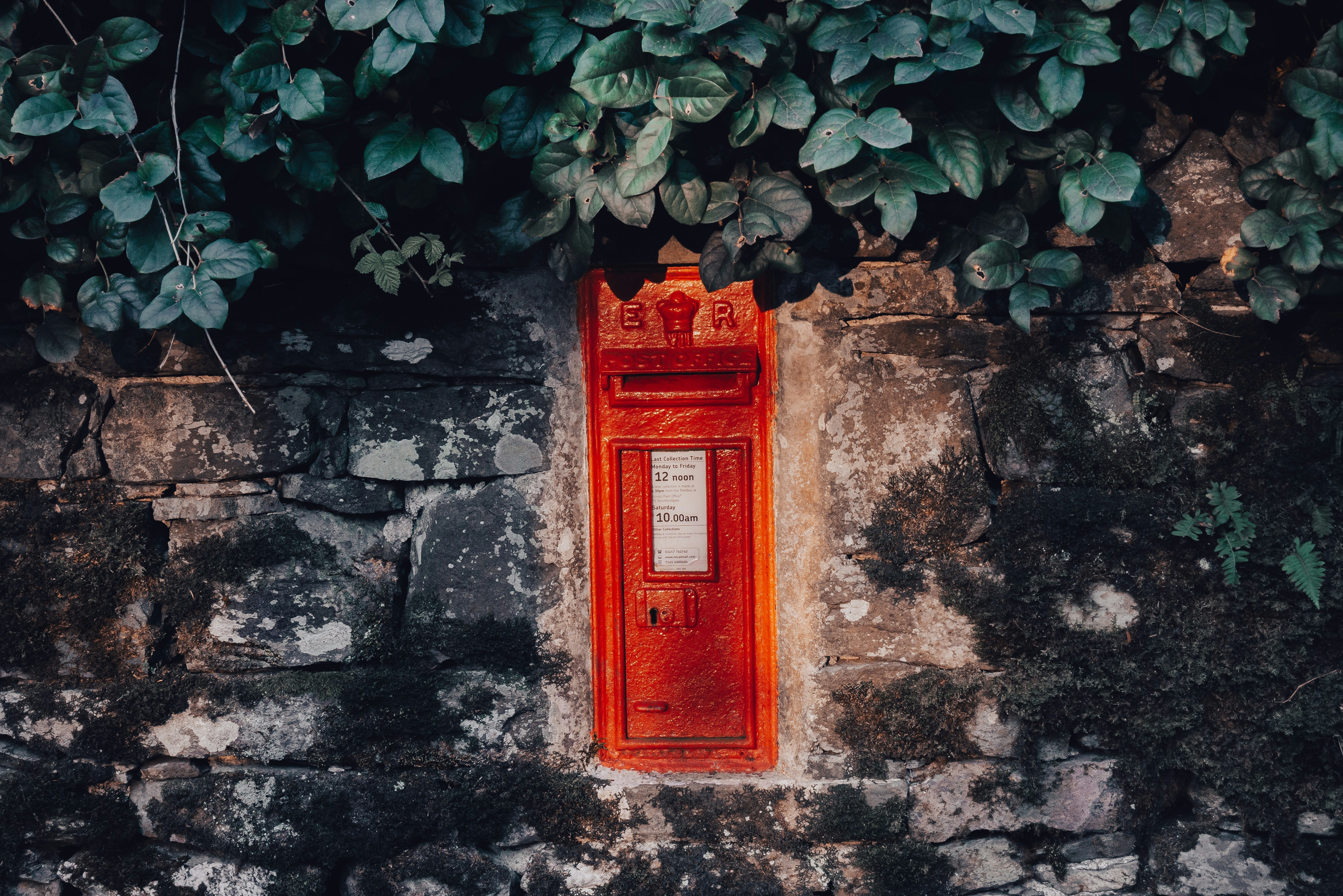 Red telephone booth on gray concrete wall photo Free Ulverston Image on Unsplash