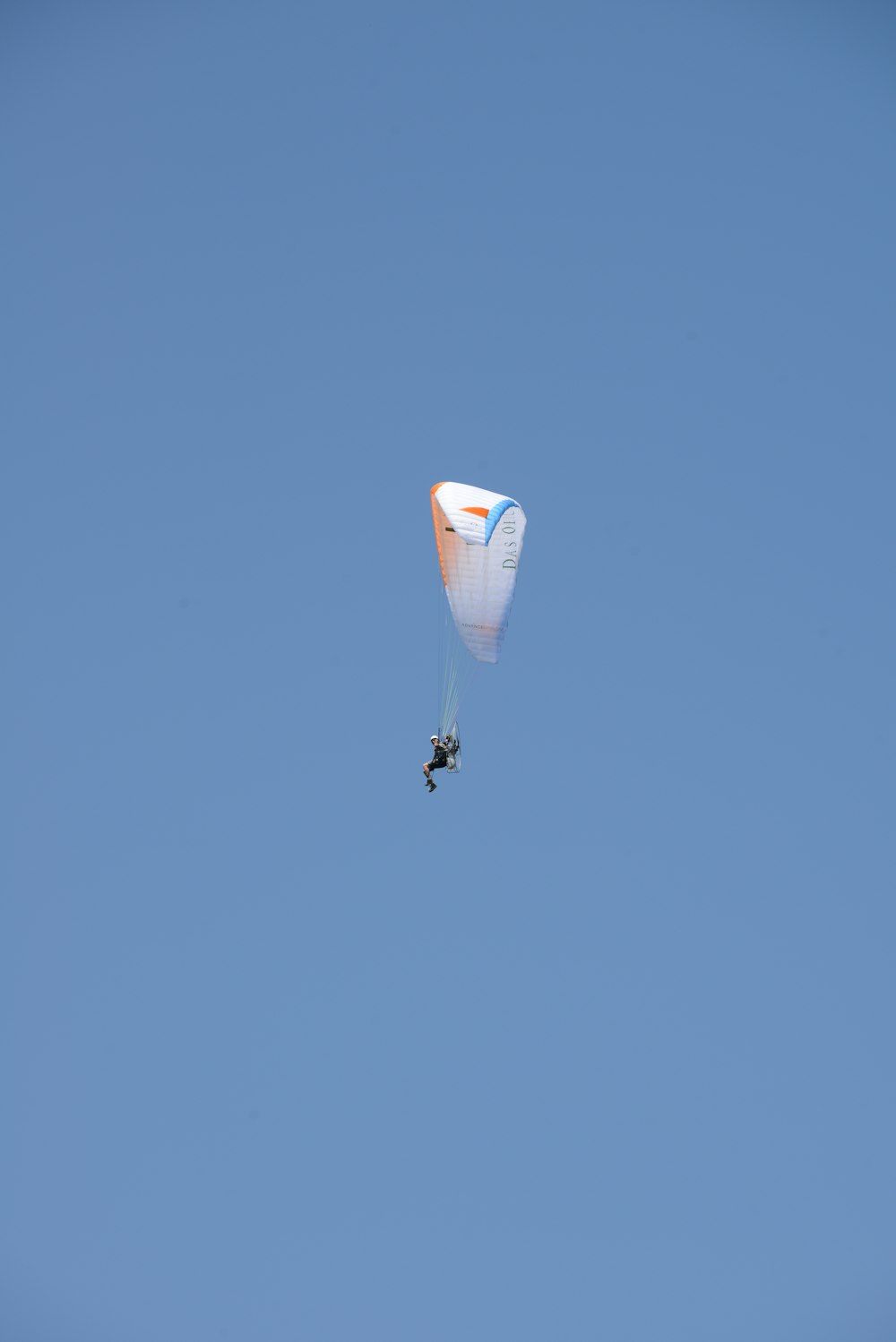 person in parachute under blue sky during daytime