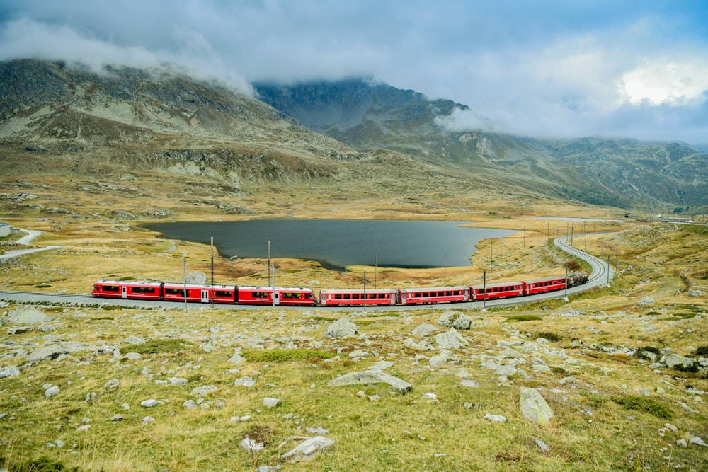 red and white boat on river near mountain during daytime