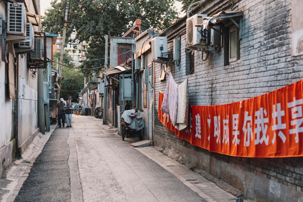 people walking on sidewalk near houses during daytime