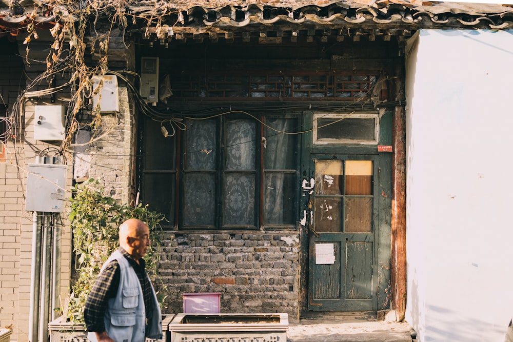 man in black jacket standing in front of brown brick building during daytime