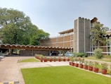 green grass field with trees and concrete building